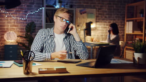 man working late at night on a phone call