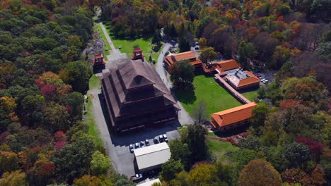 an aerial view of the chuang yen monastery on a sunny day, the leaves of the surrounding trees begin to change for the autumn season