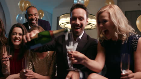 friends holding up champagne flutes together in a toast at party