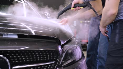 hombre que cubre el coche con cinta de poliuretano de vinilo. películas para el coche. pegatina película protectora en el coche