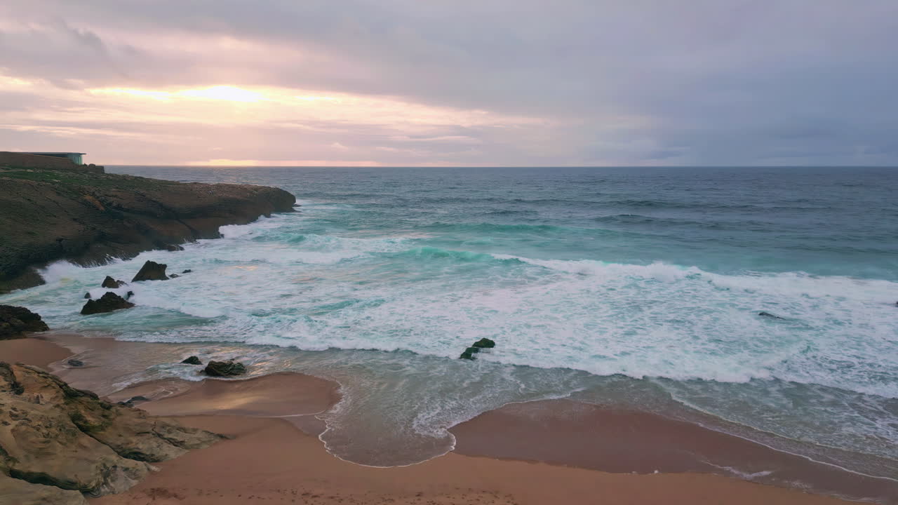 Sunrise glowing ocean landscape with waves caressing sandy coast. Sandy beach