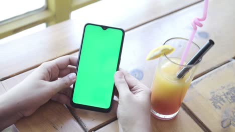 vista trasera de mujeres jóvenes usando teléfono inteligente y jugo de naranja en la mesa