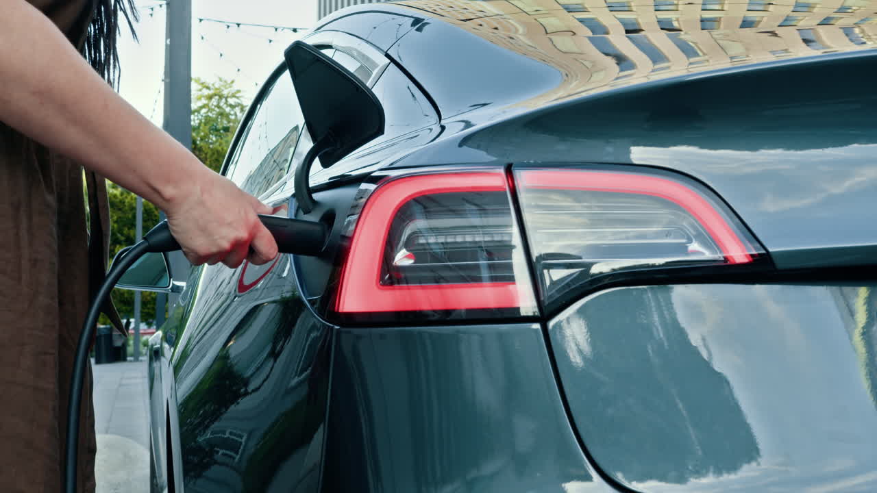 mujer cargando un coche eléctrico