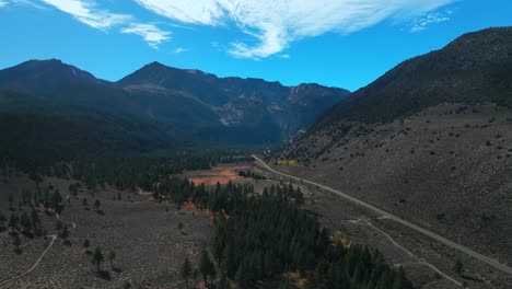 west portal entrance mountains lee vining tioga pass road yosemite national park california aerial drone ansel adams wilderness big oak flat fall yellow orange aspen trees blue skies circle right