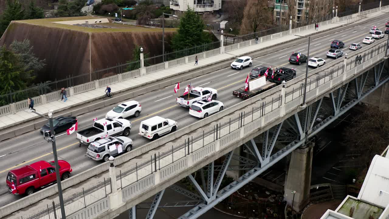 banderas canadienses y pancartas en vehículos en el puente de la calle burrard en vancouver, canadá
