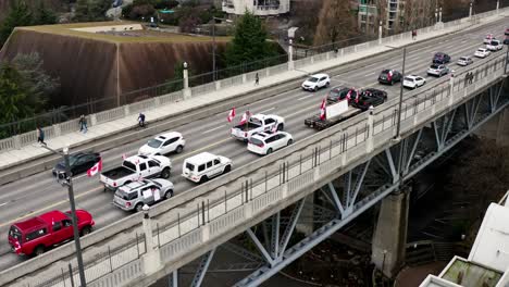 canadian flags and banner on vehicles at burrard street bridge in vancouver, canada