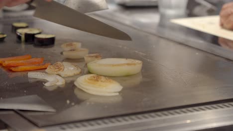 Japanese-Chef-cut-slice-onion-over-teppanyaki-table-side-dish-for-Wagyu-kobe-authentic-Meat-Osaka-Japan