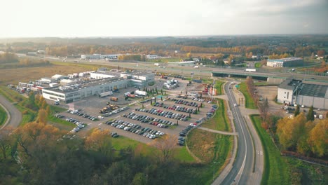 Warehouses,-huge-logistics-center-near-the-highway,-view-of-a-large-number-of-cargo-trailers-and-containers,-international-cargo-transportation,-aerial-view