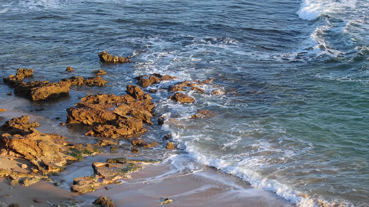 Onde che si infrangono sulle rocce di una spiaggia di Melbourne
