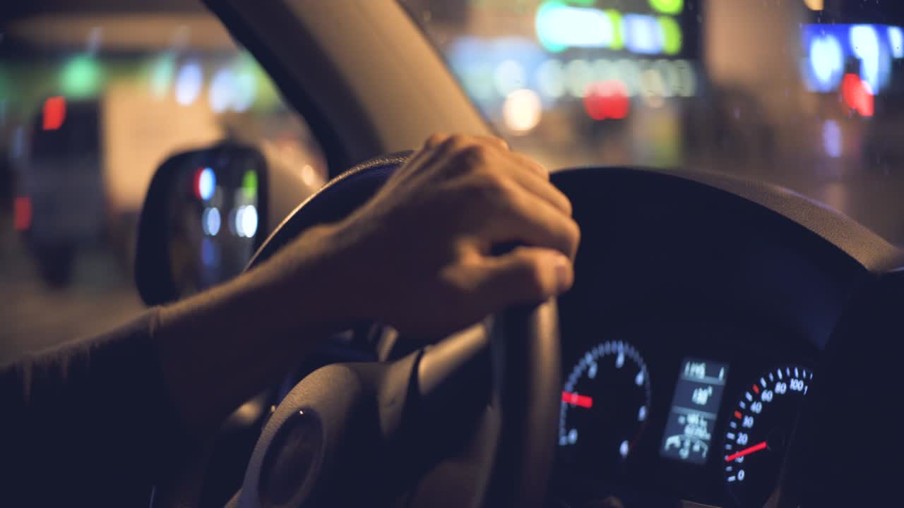 el hombre conduciendo el coche en la ciudad nocturna