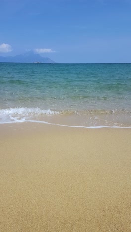 vertical video, empty sandy beach and small waves of mediterranean sea