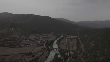 this drone video captures a stunning frontal descriptive shot of an ancient bridge over the gállego river in anzánigo, spain. a perfect blend of historical charm and natural beauty.