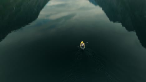 Yellow-kayak-in-middle-of-deep-lake-of-Norway,-aerial-view