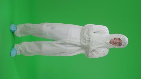full body of asian male wearing personal protective equipment uniform ppe pose with arms crossed in green screen studio
