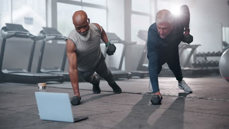two men doing pushups with weights at the gym