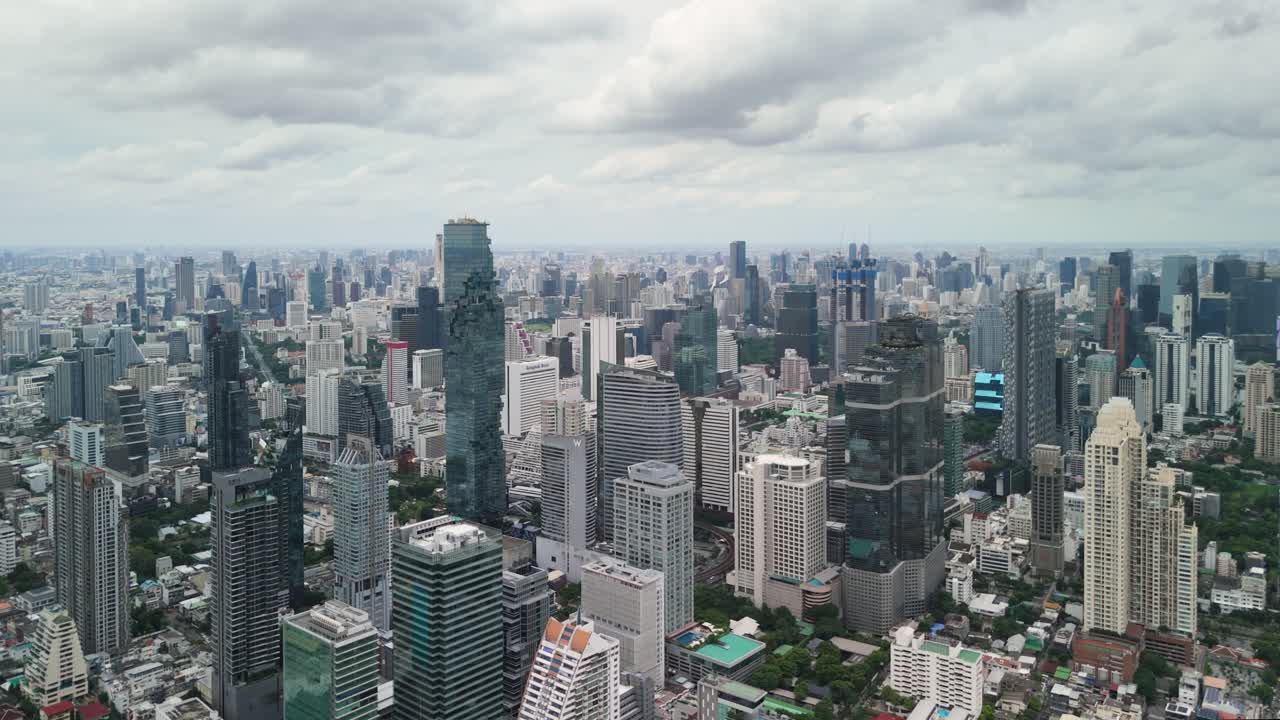 Stunning aerial cityscape view of Bangkok, Thailand, showcasing modern architecture, including the iconic The Mahanakhon skyscraper. The image captures the contrast between towering buildings