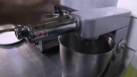 chef lanzando pasta con un accesorio mezclador