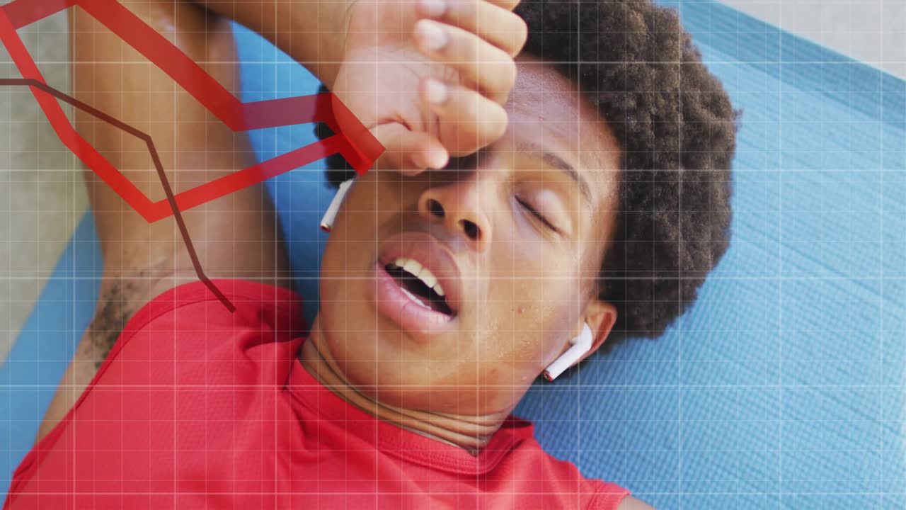 Man lying on exercise mat breathing heavily following animated fitness tracking graphs appearing