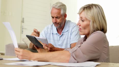 pareja estresada trabajando en sus finanzas en el sofá