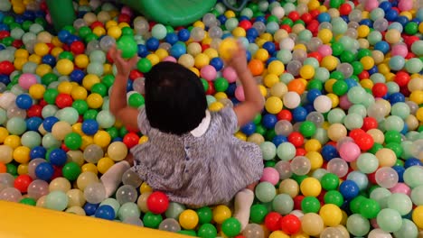 child playing in a ball pit