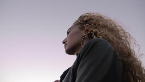 Beautiful-Woman-With-Curly-Hair-Dreaming-Alone-Under-The-Sky---Close-up-Shot