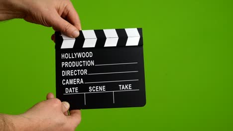 human hands hold and clap with clapperboard. beginning of scene in film or television production.