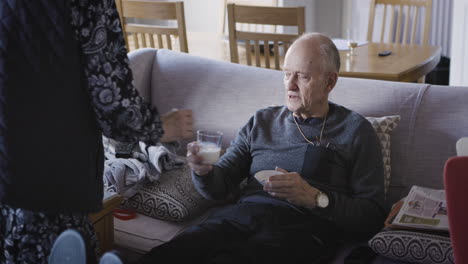 elderly man being given drink