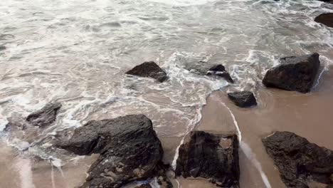 sea waves crashing into natural rock formation on the coastline shores