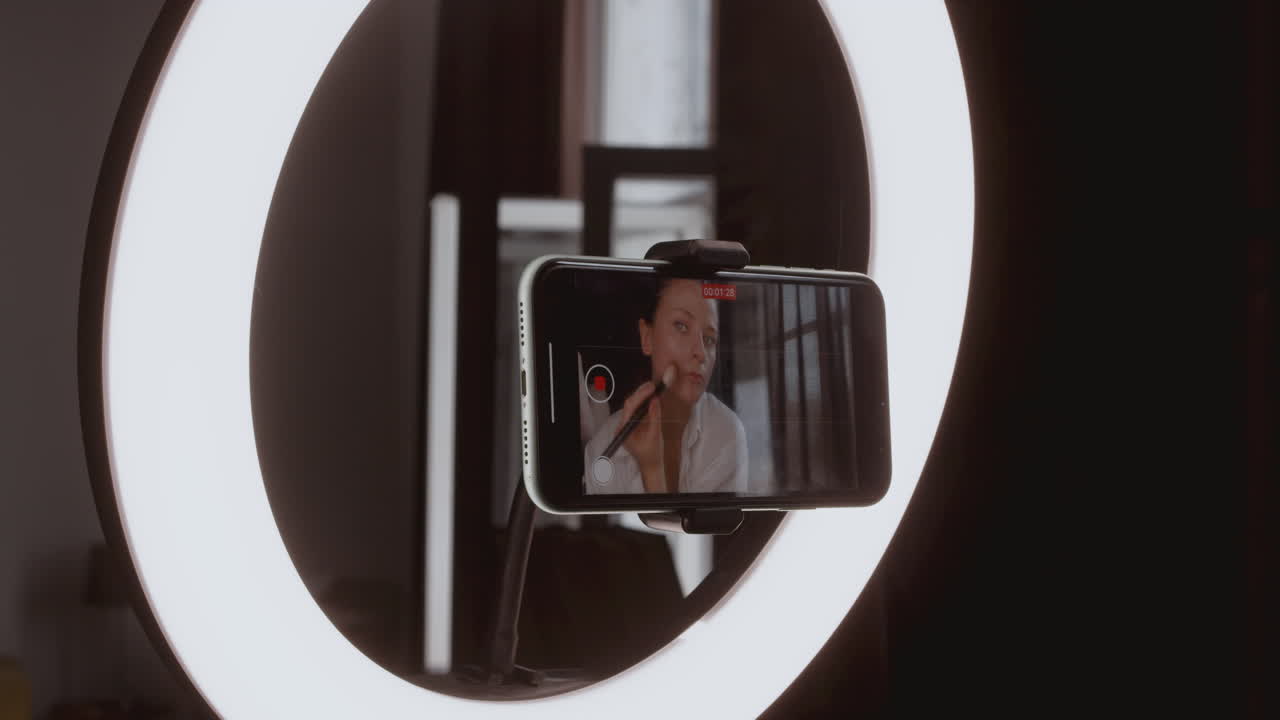 detalle de cerca de la grabación de la pantalla de un teléfono inteligente mientras una vloguera se maquilla en vivo para sus seguidores