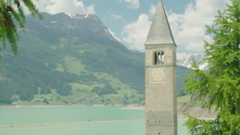 Tiro-Medio,-Rama-De-árbol-Soplada-Por-El-Viento-En-Italia,-Kirchturm-Von-Altgraun-Y-Cordillera-En-El-Fondo