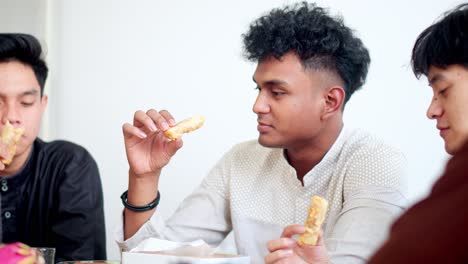 group of happy muslim friends break fasting together on iftar time at home