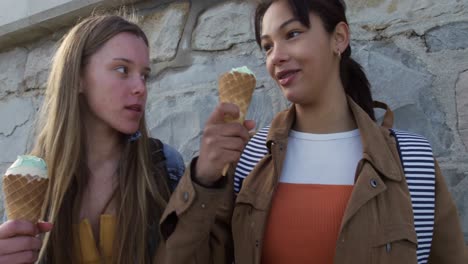 Vista-Lateral-De-Una-Chica-Caucásica-Y-De-Raza-Mixta-Comiendo-Helado-Junto-Al-Mar