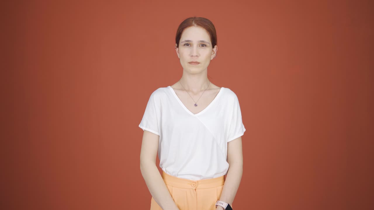 여성이 카메라를 위해 정지 표지판을 만들고 있습니다.