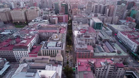Aerial-view-looking-down-over-Paseo-Huerfanos,-Santiago-metropolitan-region,-Chile-and-presidential-palace-city-landscape