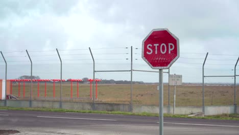 Señal-De-Stop-En-La-Carretera-Junto-A-Un-Aeropuerto-Vacío,-Símbolo-De-Vuelos-Cancelados-Y-Vacaciones-Durante-La-Pandemia-De-Covid-19