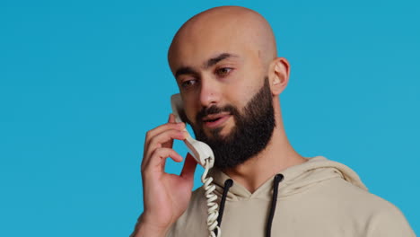 muslim adult taking call on a landline phone in studio