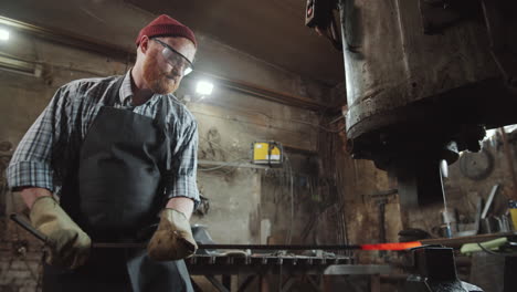 blacksmith using pneumatic forging hammer at work