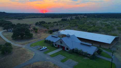 Luftbild-Texas-Ranch-Sonnenuntergang-Pferdearena-Scheune-Koppelfeld-Drohne-4k