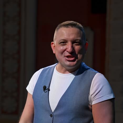 actor in medical mask on theatre scene. man rehearsing on stage and taking off protective mask while leading monologue. pandemic in the world