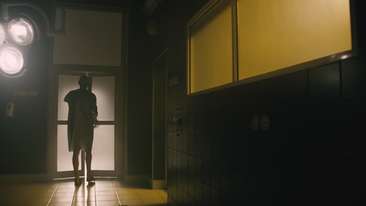 A bald man walks  in the empty operation room