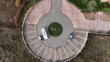 motor home camper van circling roundabout, top down descending aerial view