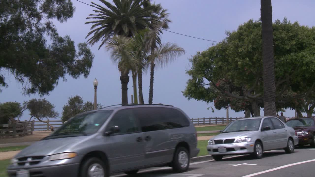 un automóvil viaja a lo largo de una calle costera en santa monica california como se ve a través de la ventana trasera en un ángulo 1