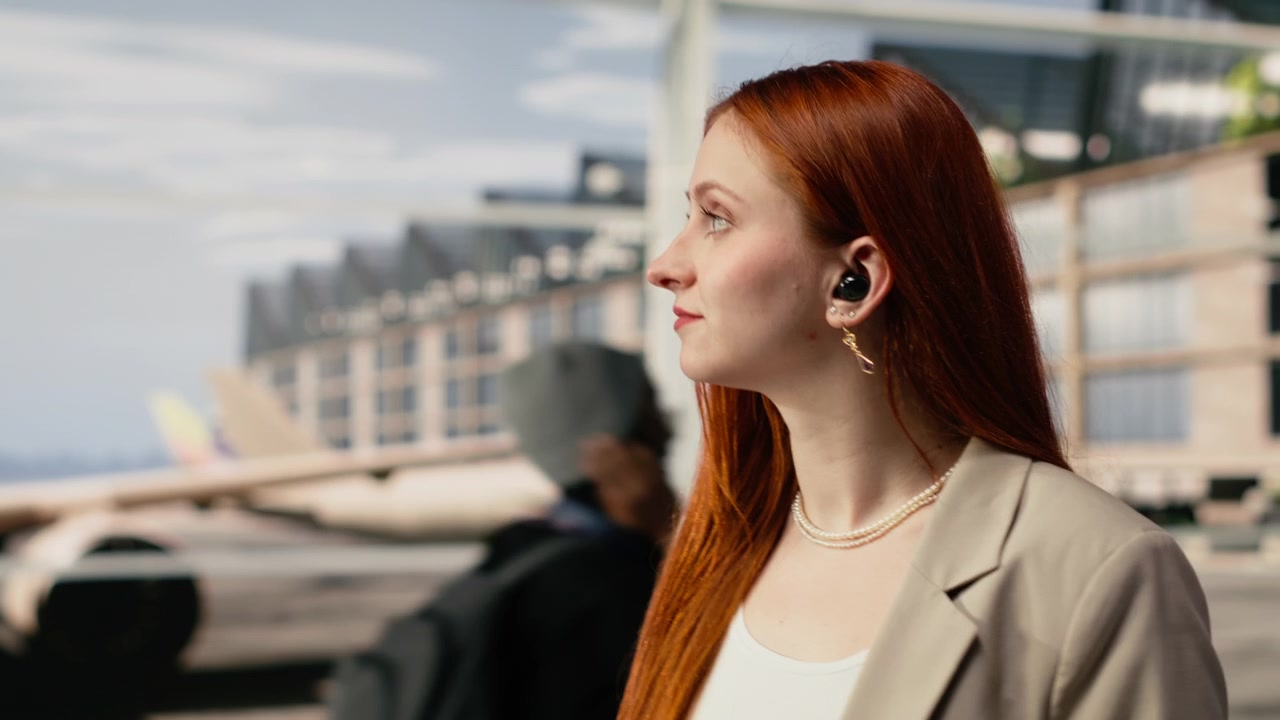 Primo piano di una donna nel terminal dell'aeroporto che usa lo smartphone per chattare con gli amici.