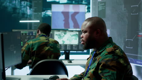 military team in a control center uses advanced technology to gather information