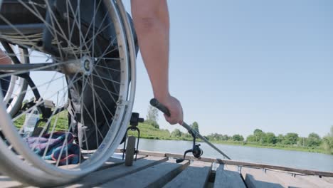 man with disabilities fishing at a lake. wheelchair. camping. summertime