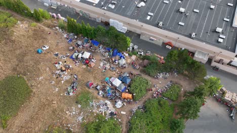 aerial shot rising above a homeless camp to reveal how close it is to major shopping facilities