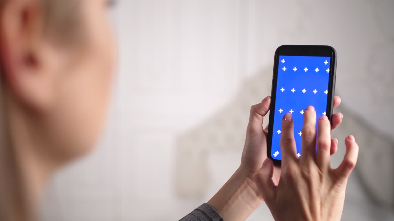 persona femenina hace zoom dentro y fuera de la pantalla chromakey azul con los dedos en la superficie.