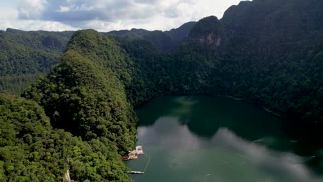 tranquil lake is surrounded by mountains with lush forest in dayang bunting island, langkawi, malaysia