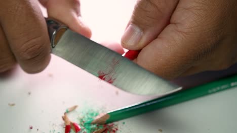 Footage-of-hands-slowly-sharpening-a-pencil-and-some-coloured-pencils-with-a-sharp-knife