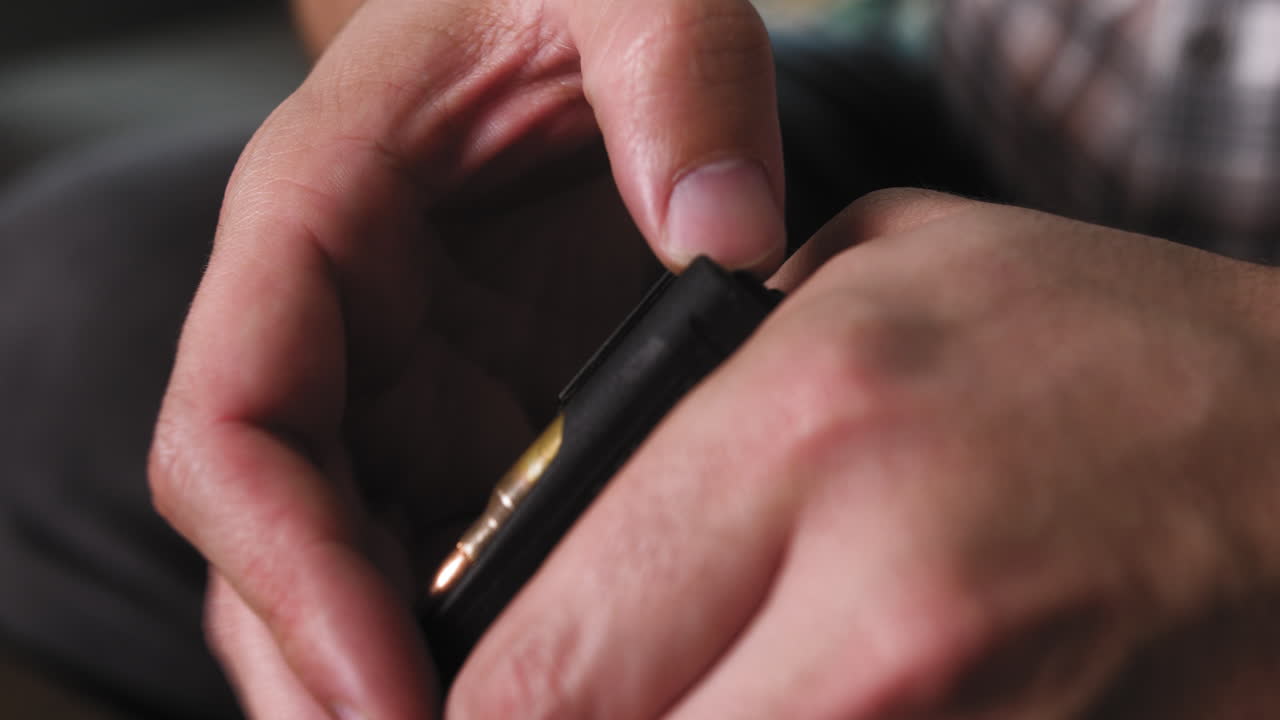 잡지에서 ar 15 총알을 내리는 남자